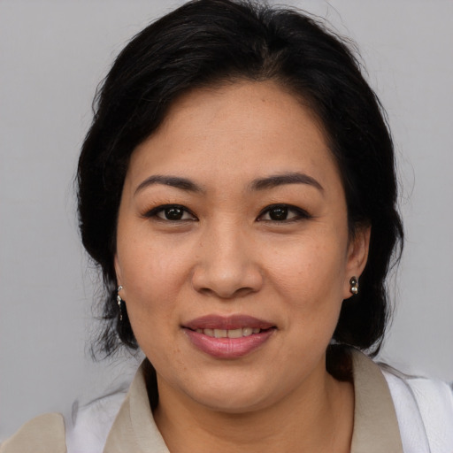 Joyful asian adult female with medium  brown hair and brown eyes