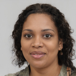 Joyful black young-adult female with long  brown hair and brown eyes