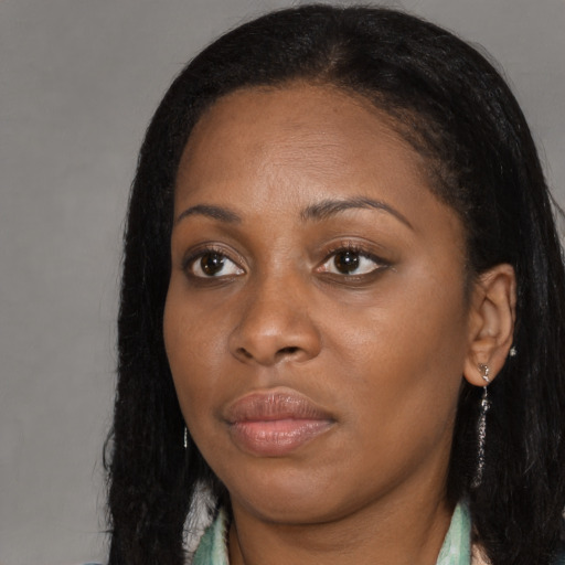Joyful black young-adult female with long  black hair and brown eyes
