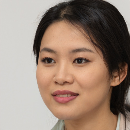 Joyful asian young-adult female with medium  black hair and brown eyes
