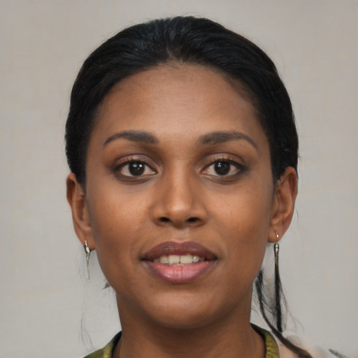Joyful black young-adult female with long  black hair and brown eyes