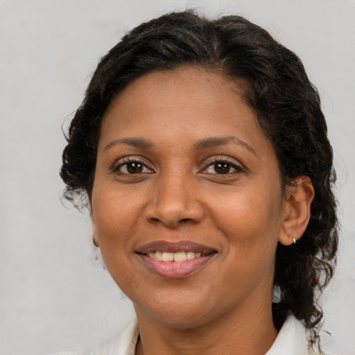 Joyful latino adult female with medium  brown hair and brown eyes