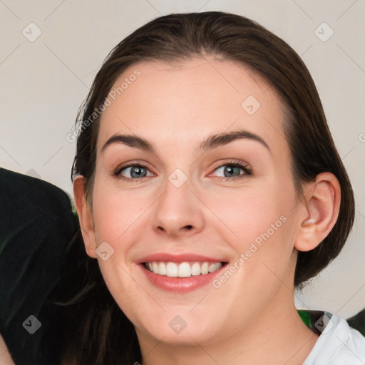 Joyful white young-adult female with medium  brown hair and grey eyes