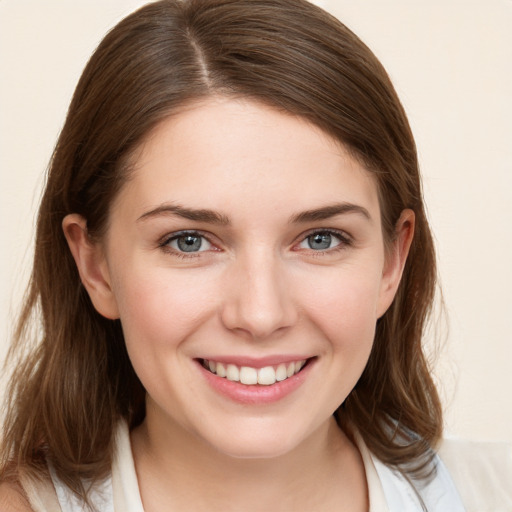 Joyful white young-adult female with medium  brown hair and blue eyes