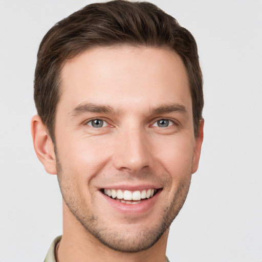 Joyful white young-adult male with short  brown hair and grey eyes