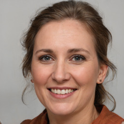 Joyful white adult female with medium  brown hair and brown eyes