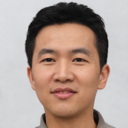 Joyful asian young-adult male with short  black hair and brown eyes