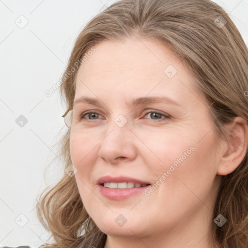 Joyful white young-adult female with long  brown hair and blue eyes