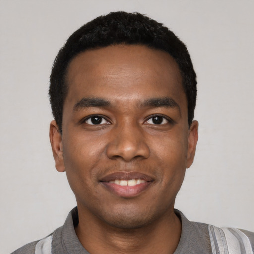 Joyful black young-adult male with short  black hair and brown eyes