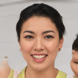 Joyful asian young-adult female with medium  brown hair and brown eyes