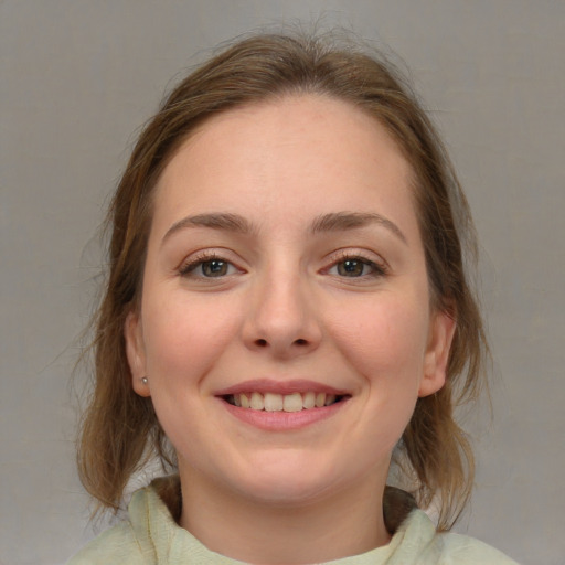 Joyful white young-adult female with medium  brown hair and grey eyes