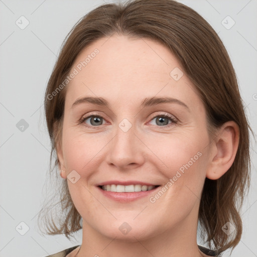 Joyful white young-adult female with medium  brown hair and grey eyes