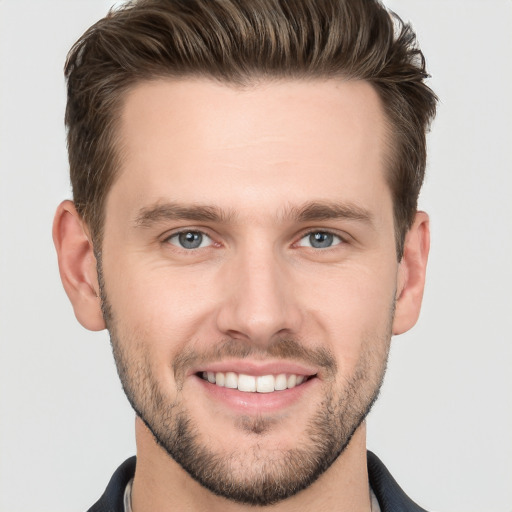 Joyful white young-adult male with short  brown hair and grey eyes