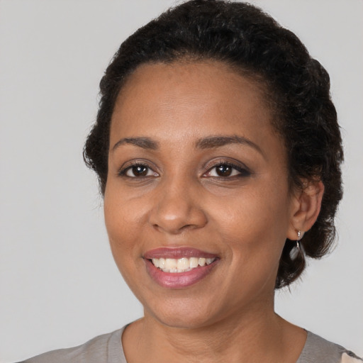 Joyful black adult female with short  black hair and brown eyes