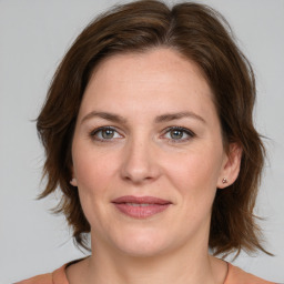 Joyful white young-adult female with medium  brown hair and green eyes