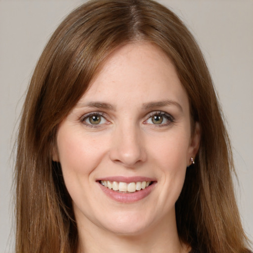 Joyful white young-adult female with long  brown hair and green eyes