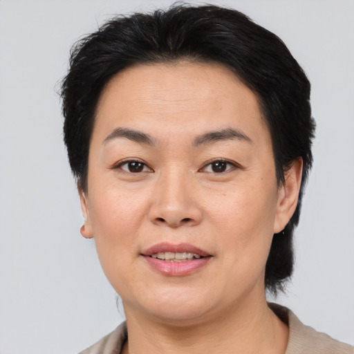 Joyful asian adult female with medium  brown hair and brown eyes
