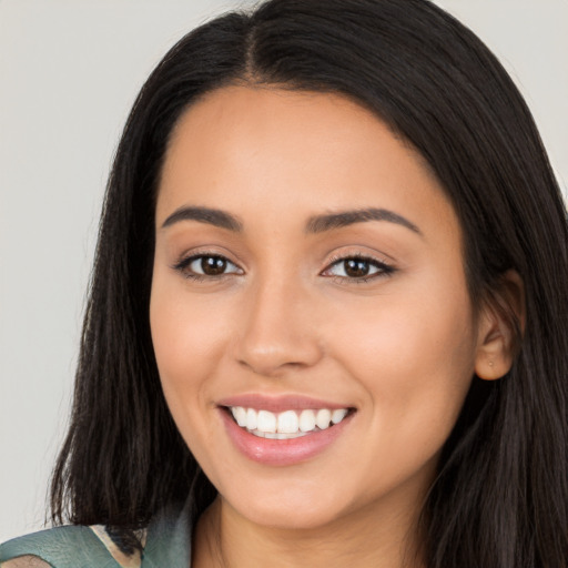 Joyful latino young-adult female with long  black hair and brown eyes