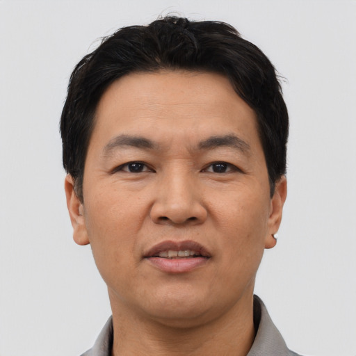 Joyful asian adult male with short  black hair and brown eyes
