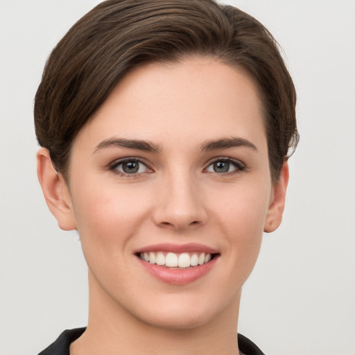 Joyful white young-adult female with short  brown hair and grey eyes