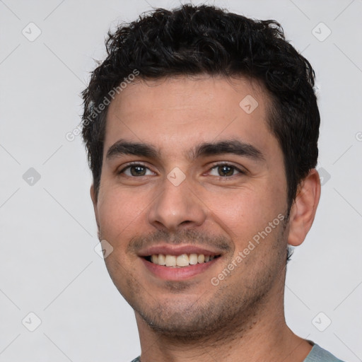 Joyful white young-adult male with short  black hair and brown eyes
