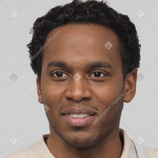 Joyful black young-adult male with short  black hair and brown eyes