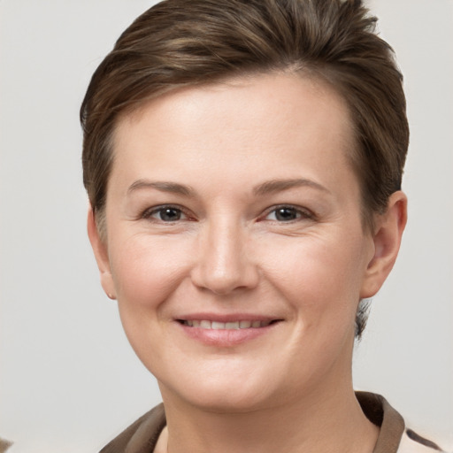 Joyful white young-adult female with short  brown hair and grey eyes