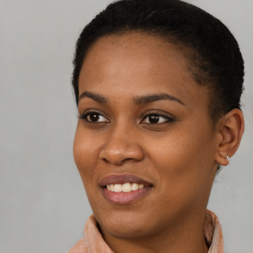 Joyful black young-adult female with short  brown hair and brown eyes