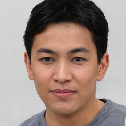 Joyful asian young-adult male with short  black hair and brown eyes
