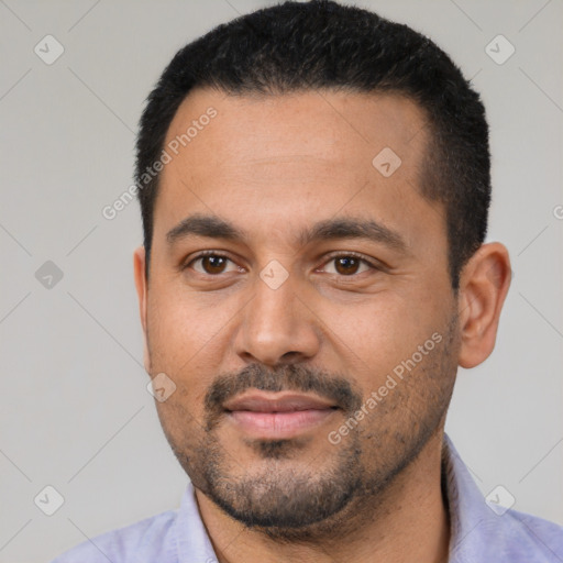 Joyful latino young-adult male with short  black hair and brown eyes