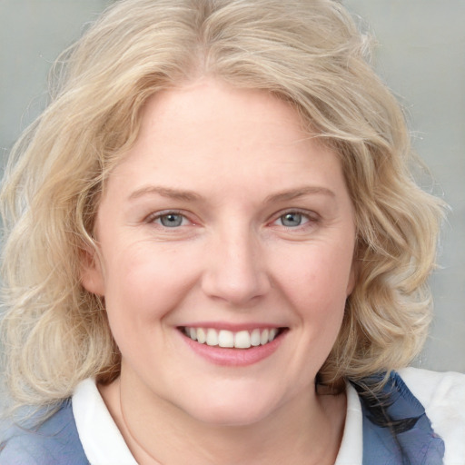 Joyful white young-adult female with medium  blond hair and blue eyes