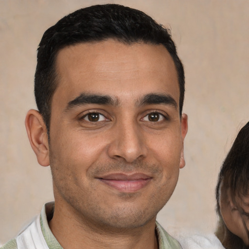 Joyful white young-adult male with short  brown hair and brown eyes
