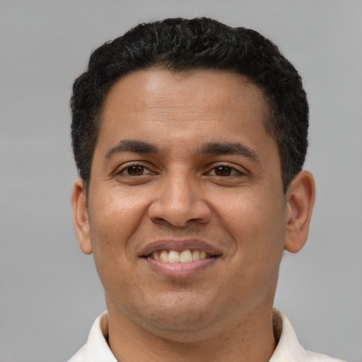 Joyful latino adult male with short  brown hair and brown eyes