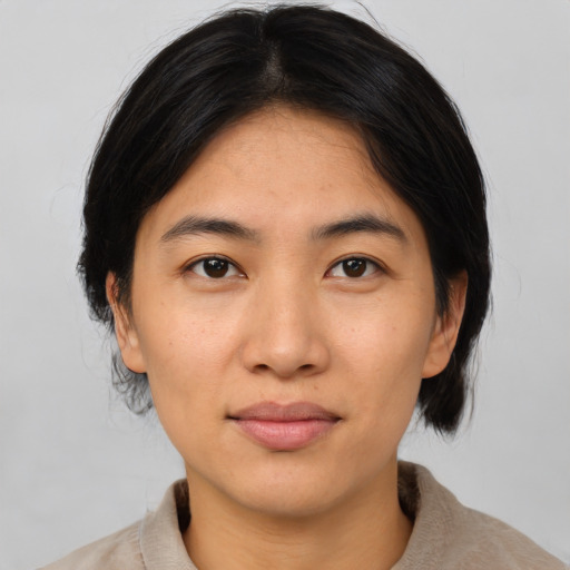 Joyful asian young-adult female with medium  brown hair and brown eyes