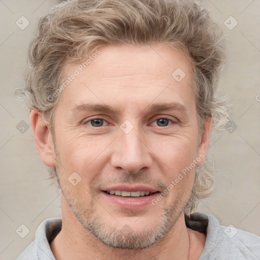 Joyful white adult male with short  brown hair and grey eyes