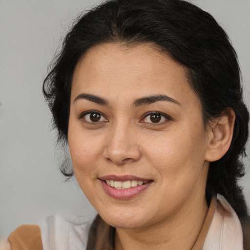 Joyful latino young-adult female with medium  brown hair and brown eyes