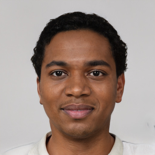Joyful black young-adult male with short  black hair and brown eyes