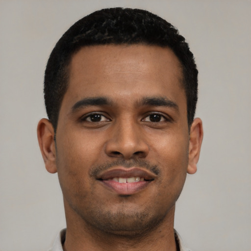 Joyful black young-adult male with short  black hair and brown eyes