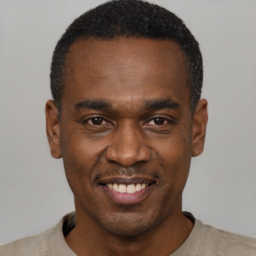 Joyful black young-adult male with short  black hair and brown eyes