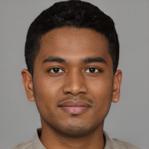 Joyful black young-adult male with short  black hair and brown eyes