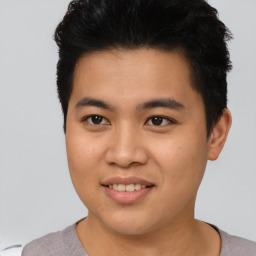 Joyful asian young-adult male with short  brown hair and brown eyes