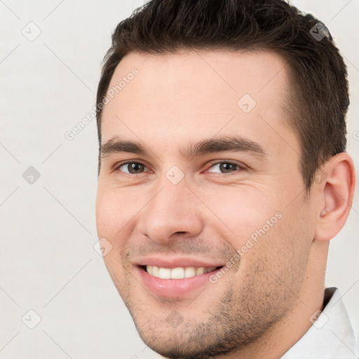 Joyful white young-adult male with short  brown hair and brown eyes