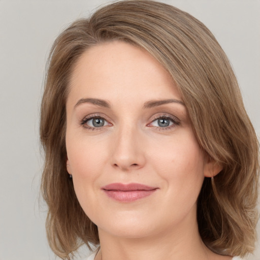 Joyful white young-adult female with medium  brown hair and green eyes