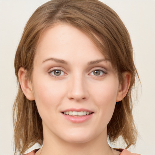 Joyful white young-adult female with medium  brown hair and green eyes