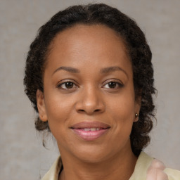 Joyful black adult female with medium  brown hair and brown eyes