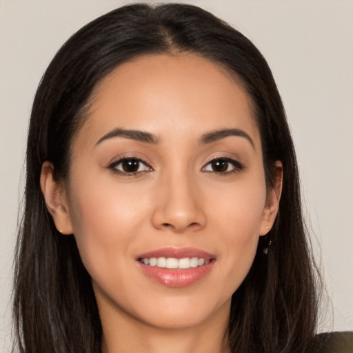 Joyful latino young-adult female with long  brown hair and brown eyes