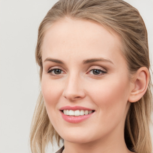 Joyful white young-adult female with long  brown hair and blue eyes