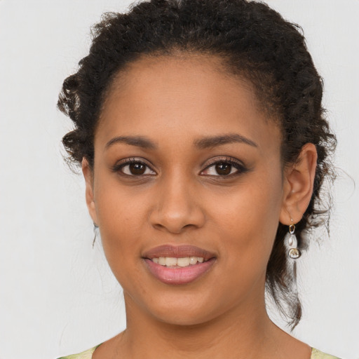 Joyful black young-adult female with long  brown hair and brown eyes