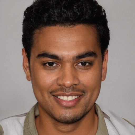 Joyful black young-adult male with short  brown hair and brown eyes
