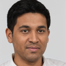 Joyful latino young-adult male with short  black hair and brown eyes